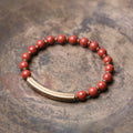 Layered retro ethnic bracelet for men and women with stone beads and brass accents on a wrist.