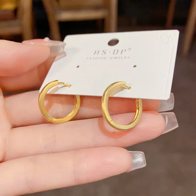 Women's simple geometric round copper ear clips with real gold plating in gold and silver colours showing eyelet design detail