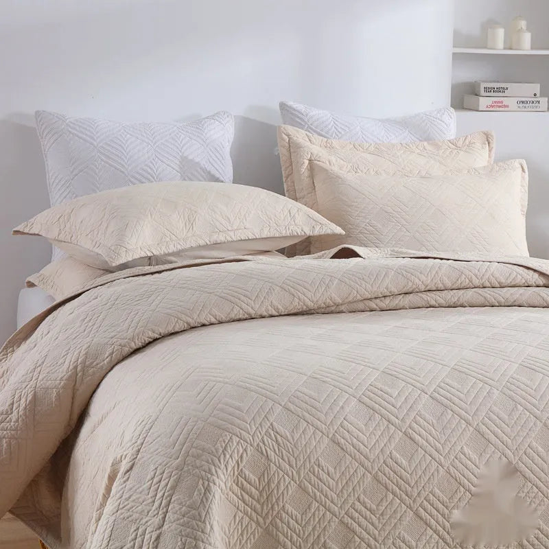 Pure cotton double-sided bed cover three-piece set in a plain colour laid on a bed.