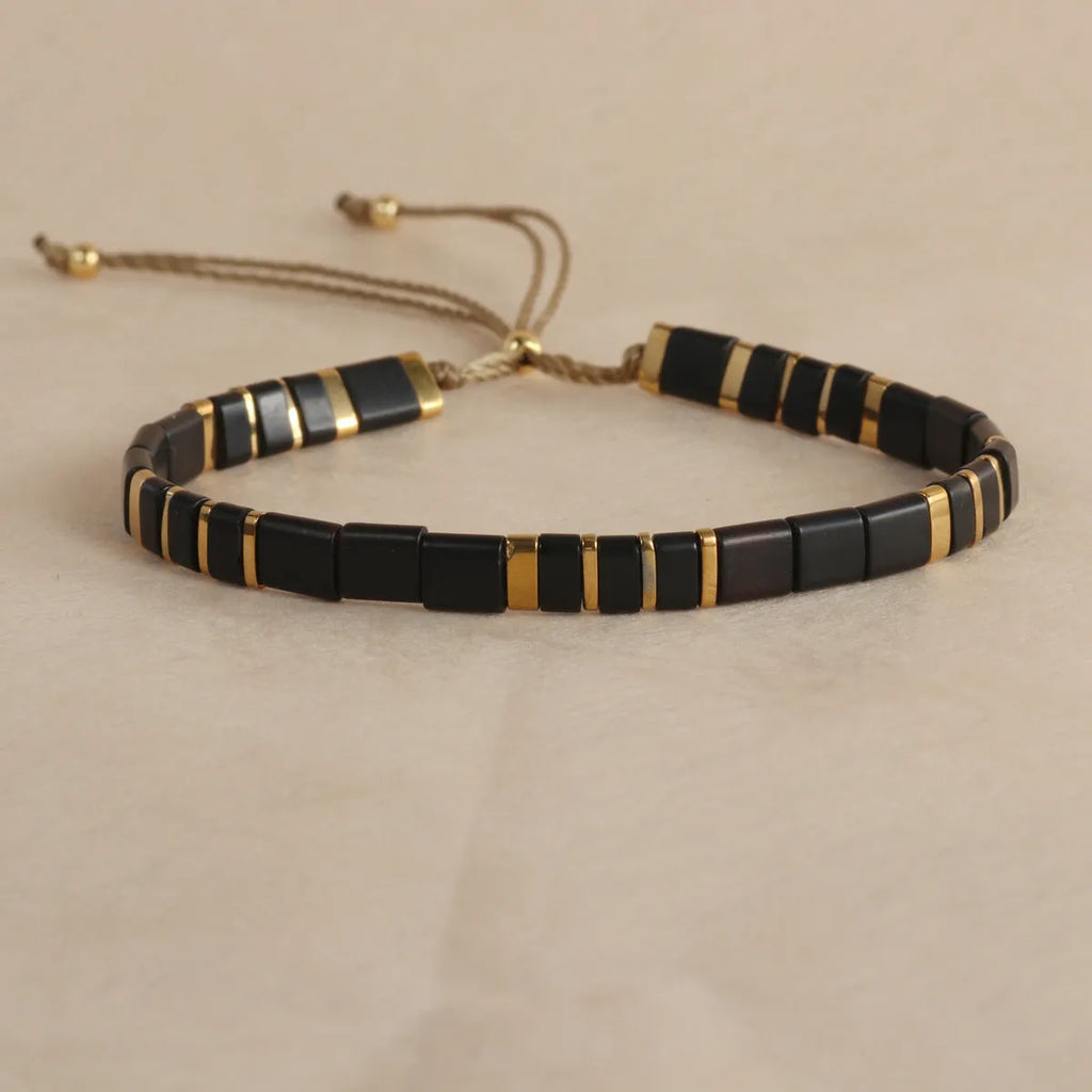 Geometric round glass bead bracelet in milky white, black, green, blue, or red.