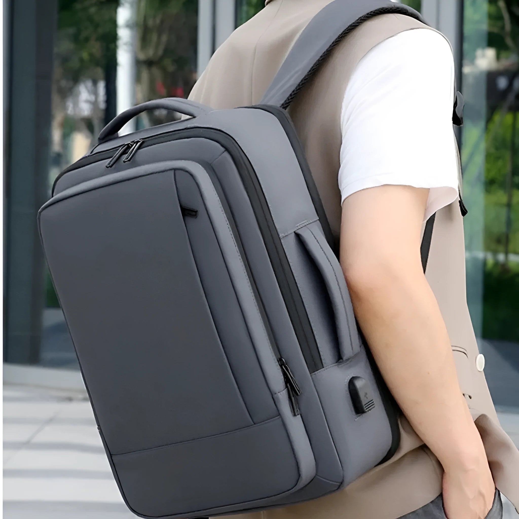 Black Oxford cloth waterproof backpack with curved shoulder strap, shown with a laptop compartment open.
