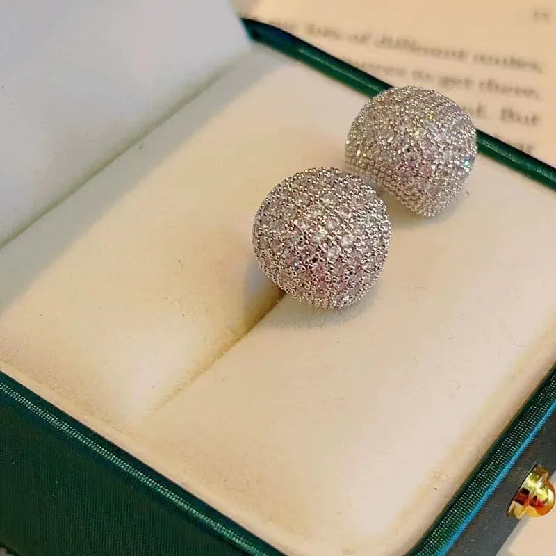 Drop-shaped geometric golden beans and diamond ear clip earrings in gold and white colours.
