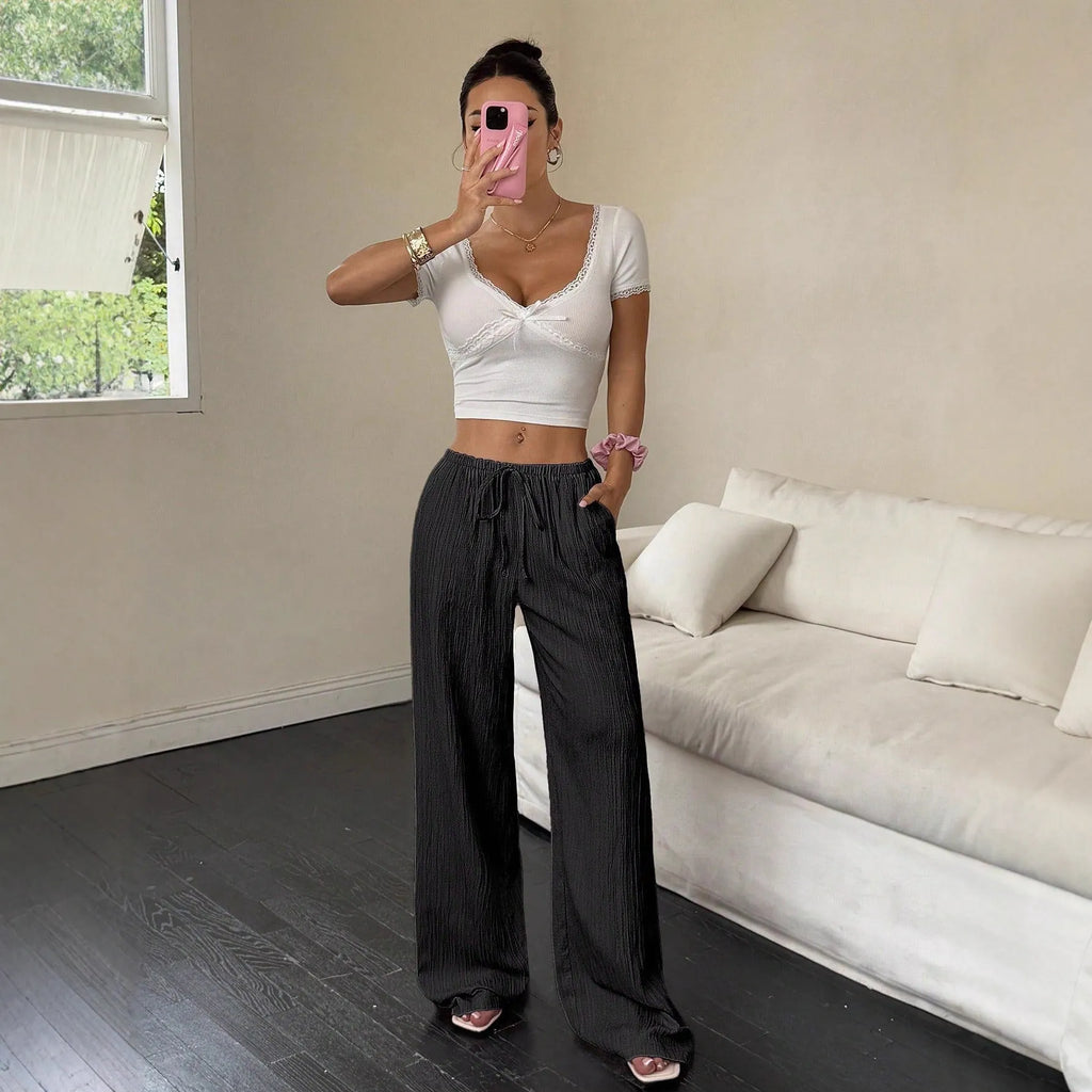 Women's black casual trousers with a lace-up waist detail and wide-leg silhouette.