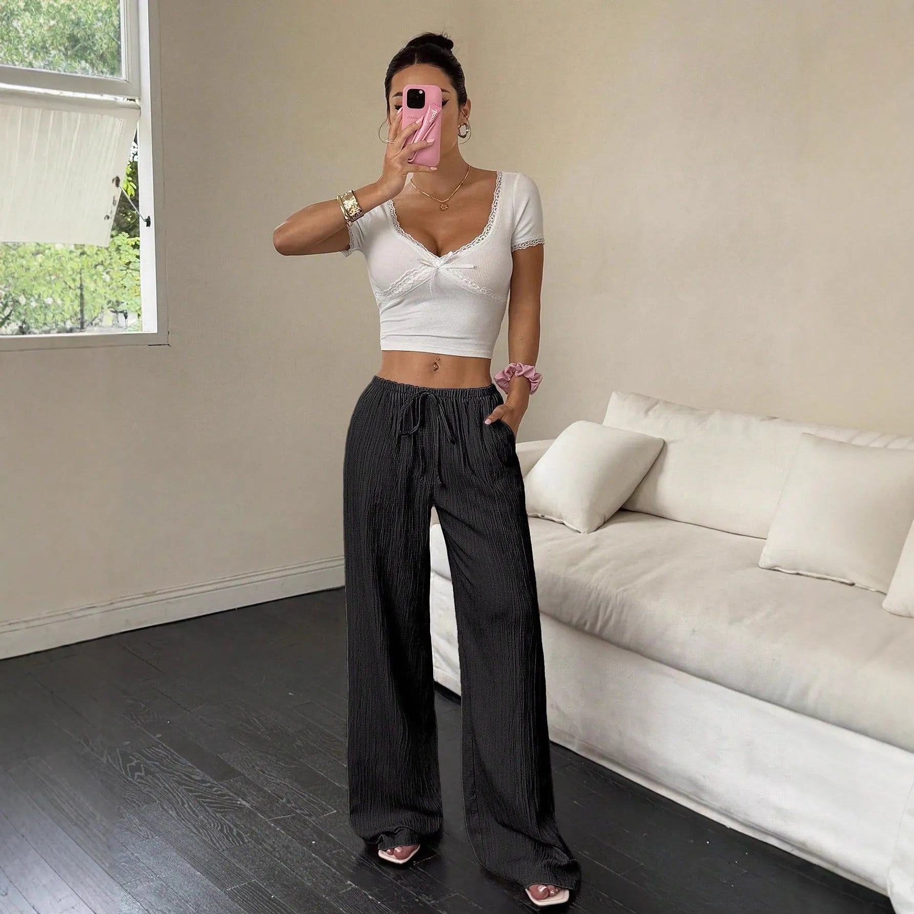 Women's black casual trousers with a lace-up waist detail and wide-leg silhouette.