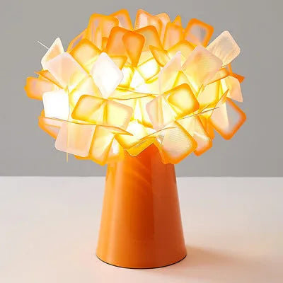 Nordic style decorative table lamp with metal base in a choice of six colours on a wooden bedside table.