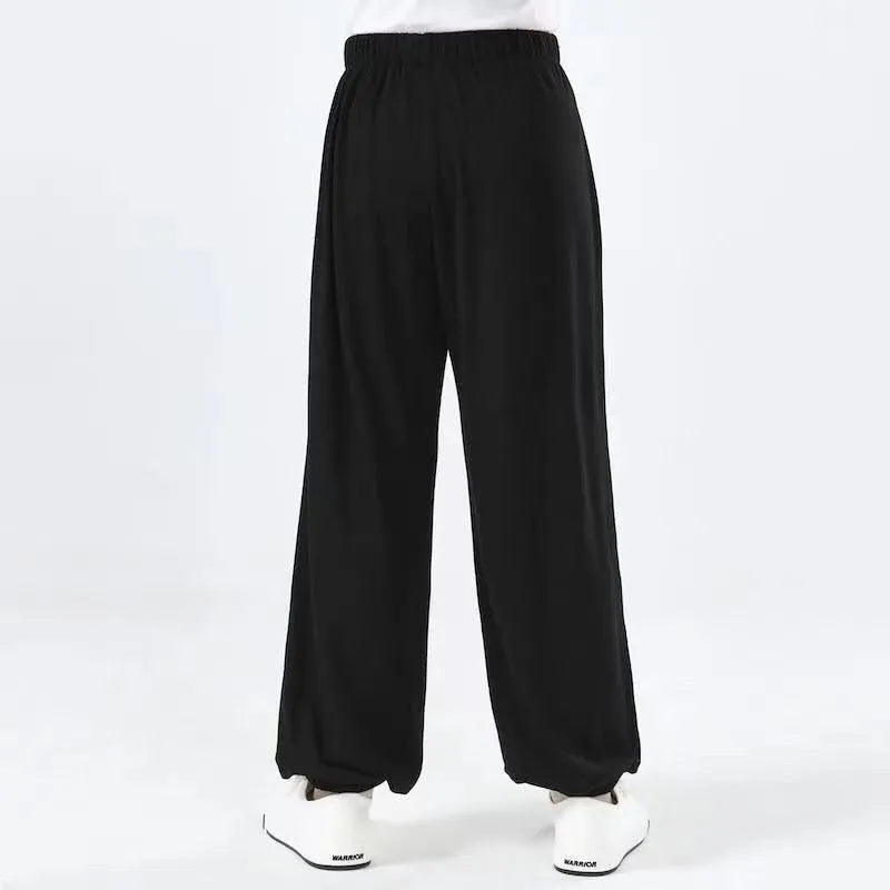 Child wearing black high elasticity Sanda practice pants made from spandex Lycra for martial arts training.
