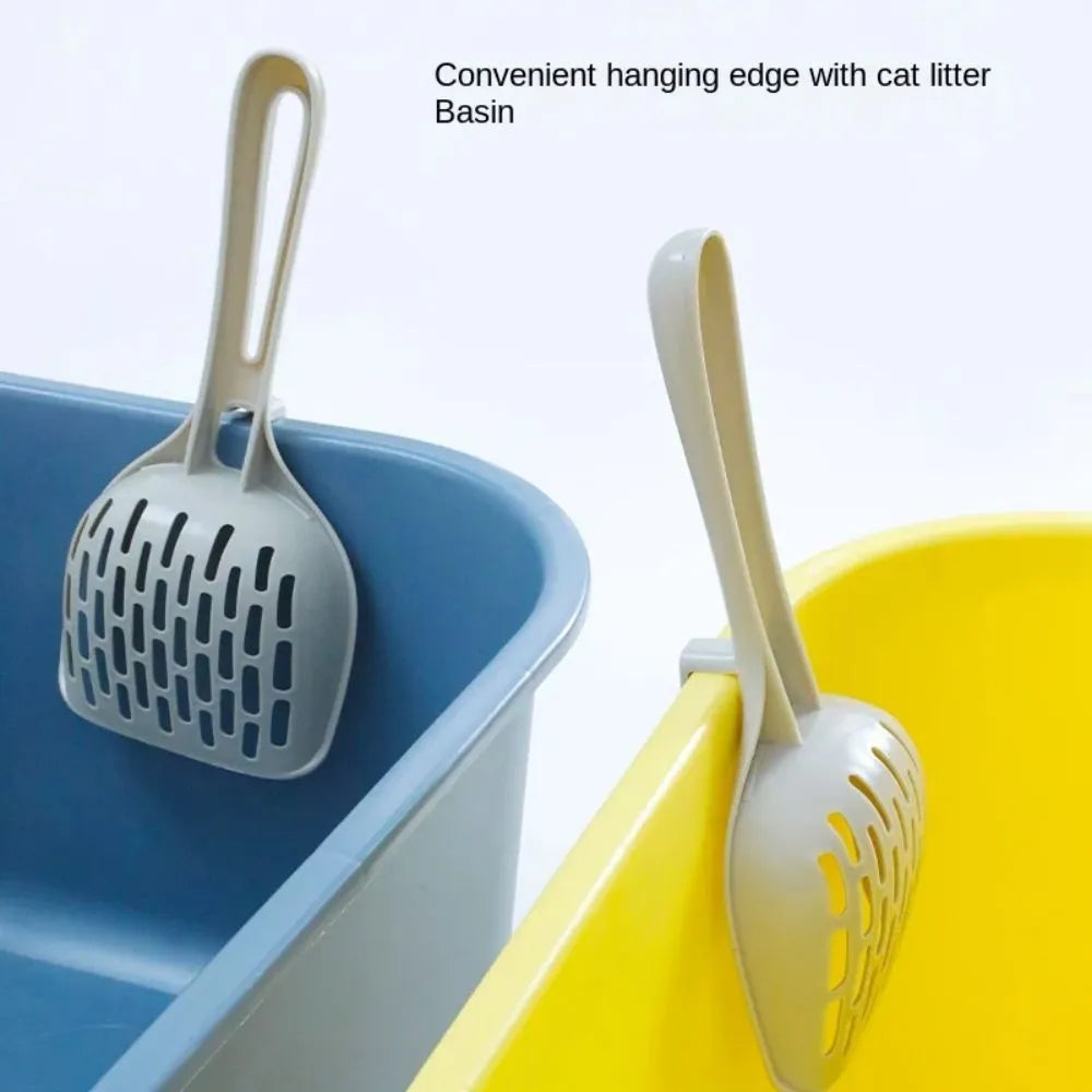 Grey plastic cat litter scoop with attached stand, shown next to a litter box.