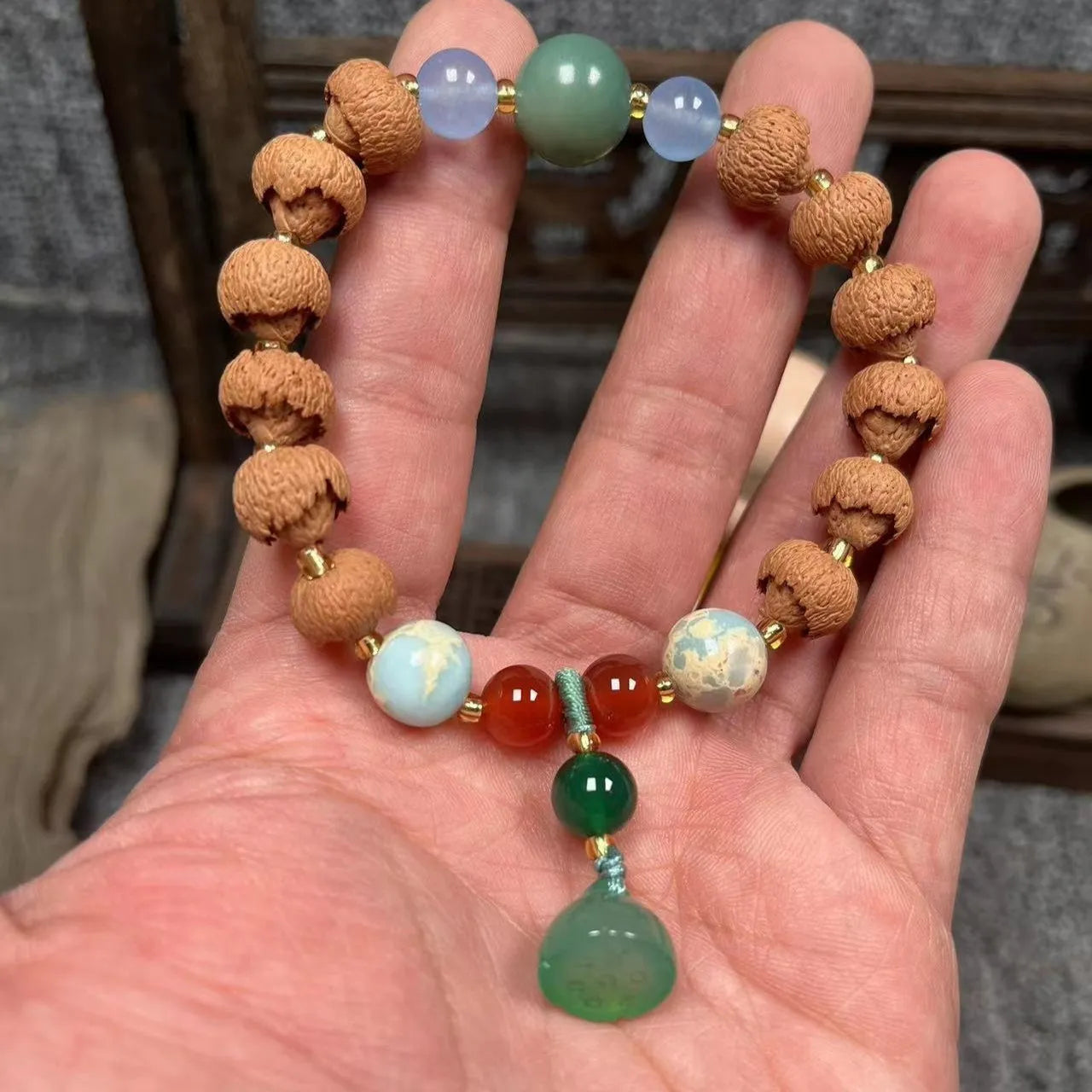 Carved Bodhi root bracelet with white jade, lotus, and pumpkin beads in various sizes.
