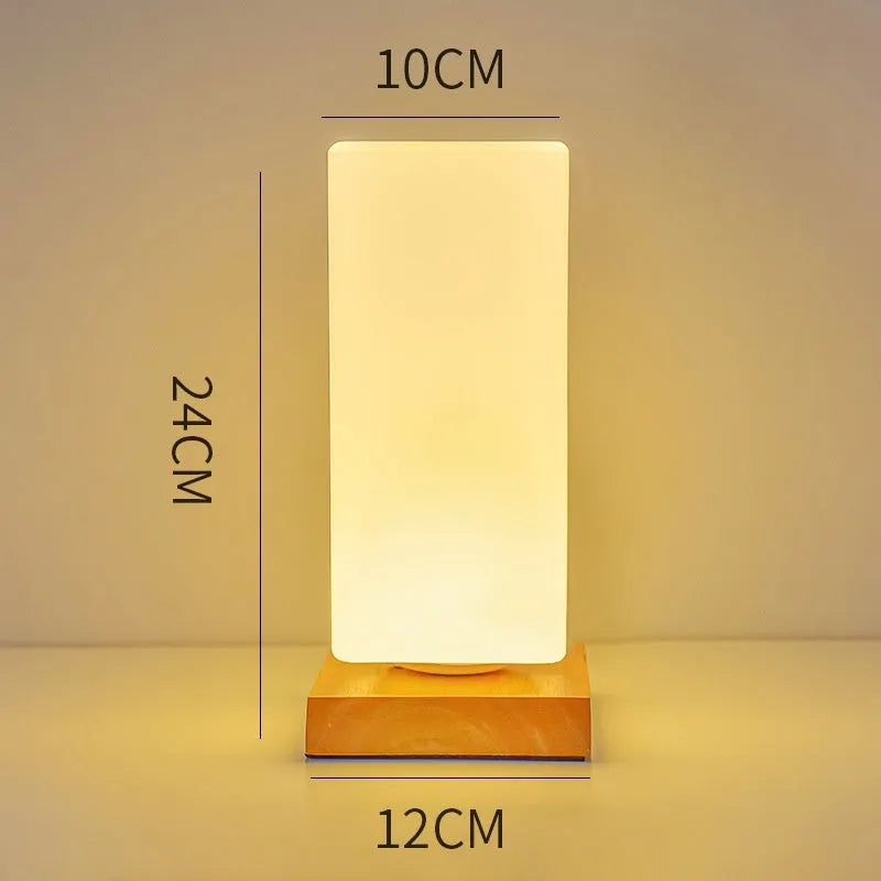 Nordic solid wood base USB table lamp with a white geometric shade on a wooden table.