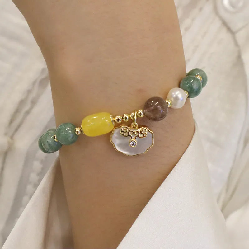 Green jade shell bracelet with adjustable silver chain on a wrist.