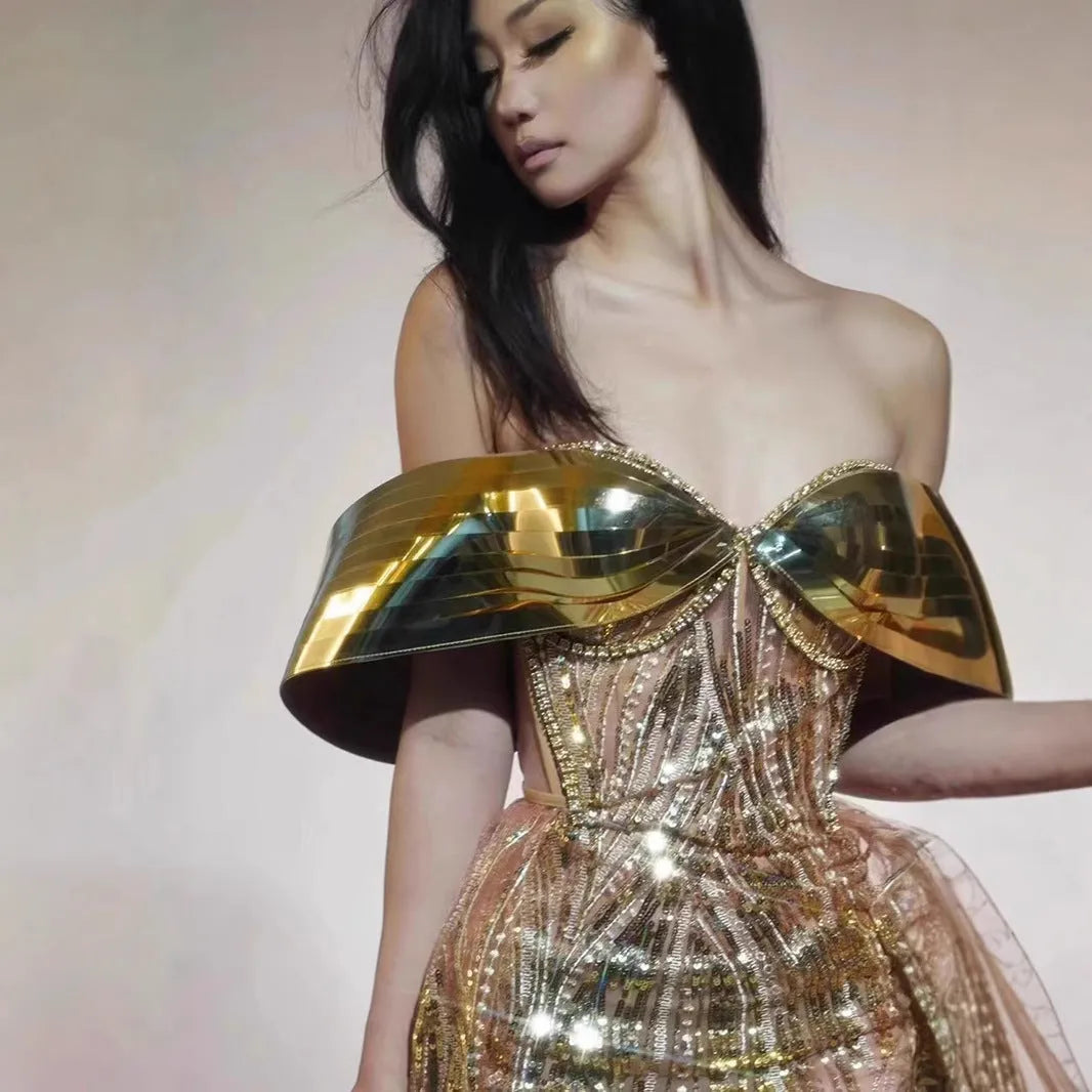 Gold strapless long dress with sequined tulle skirt and high side split, worn as formal evening wear.