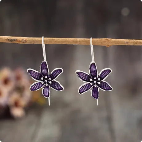 A pair of purple flower-shaped alloy earrings with an electroplated finish.
