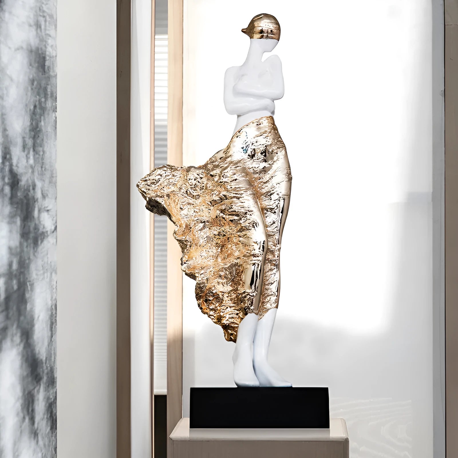 Tall modern minimalist sculpture ornament in rose gold finish on a wooden surface.
