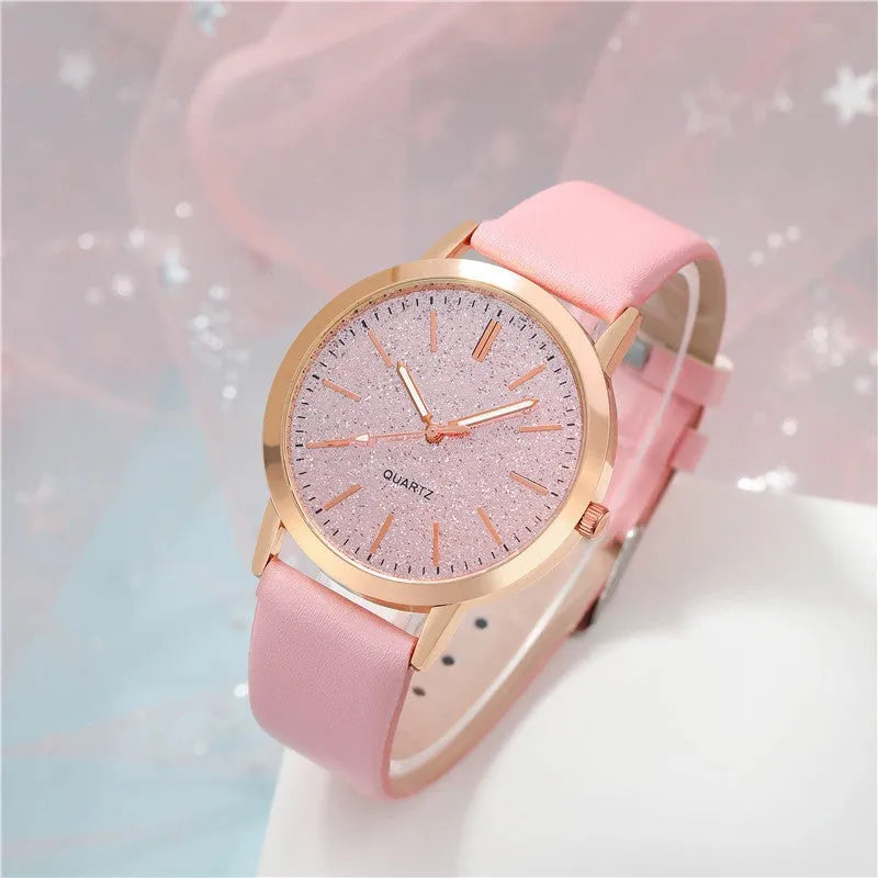 Women's pink quartz watch set with faux leather strap and bracelet on a light background