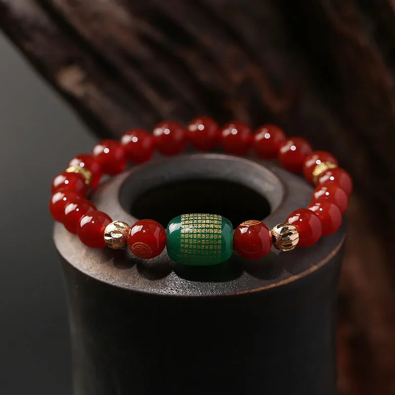 Agate Guanyin prayer bead bracelet in green or red on a wrist, showing auspicious patterns and charm.
