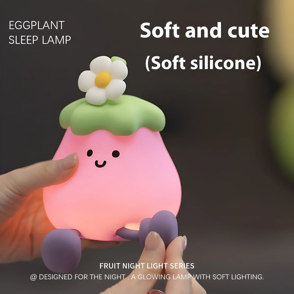 Cartoon eggplant-shaped small night lamp with soft yellow glow, shown next to a broccoli design variant.
