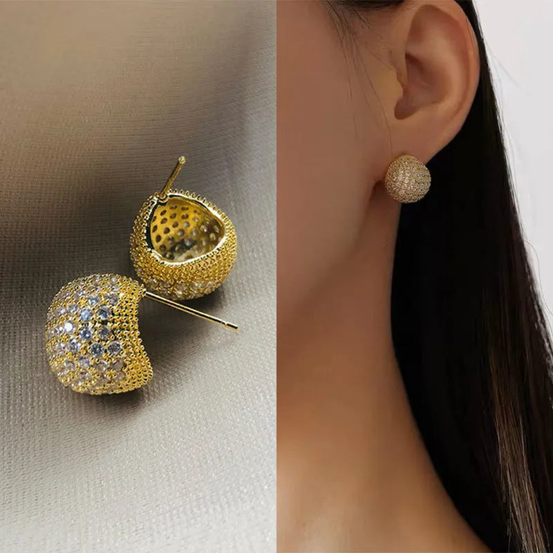 Drop-shaped geometric golden beans and diamond ear clip earrings in gold and white colours.