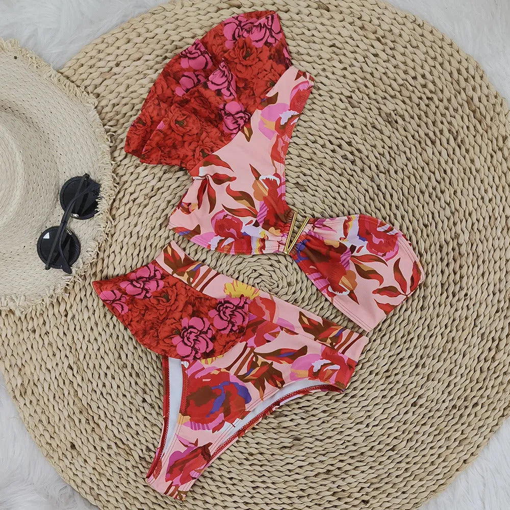 Women's pink one-shoulder ruffled bikini with red flowers and high-waist briefs.