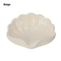 White or pink plastic shell-shaped soap dish for bathroom use.