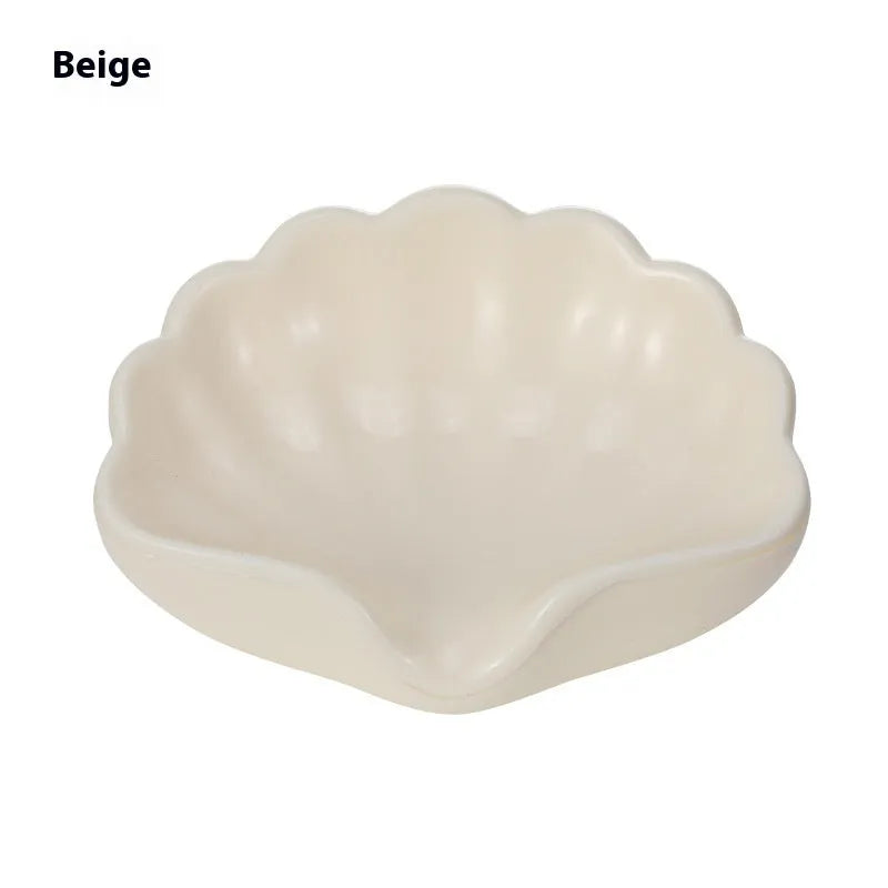 White or pink plastic shell-shaped soap dish for bathroom use.