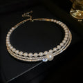 Close-up of a curved round silver-tone alloy necklace resting on a collarbone.