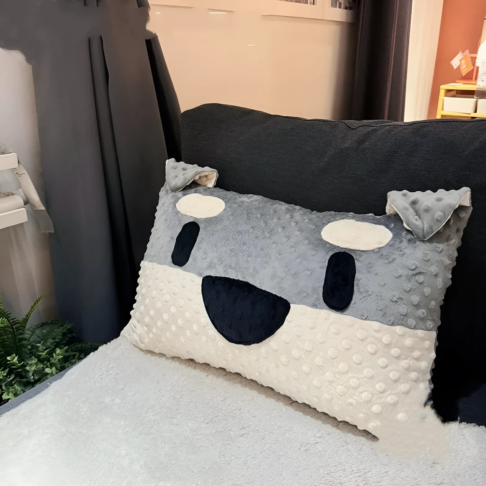 Grey schnauzer and white West Highland puppy decorative cushion pillow on a sofa.