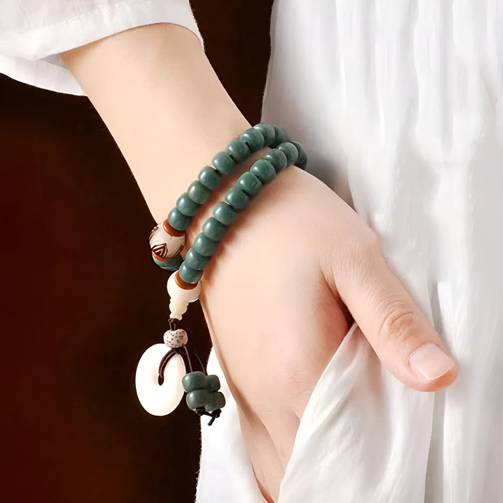 White jade and green sandalwood Bodhi seed bracelet showing either the safety buckle or lotus clasp fastening.