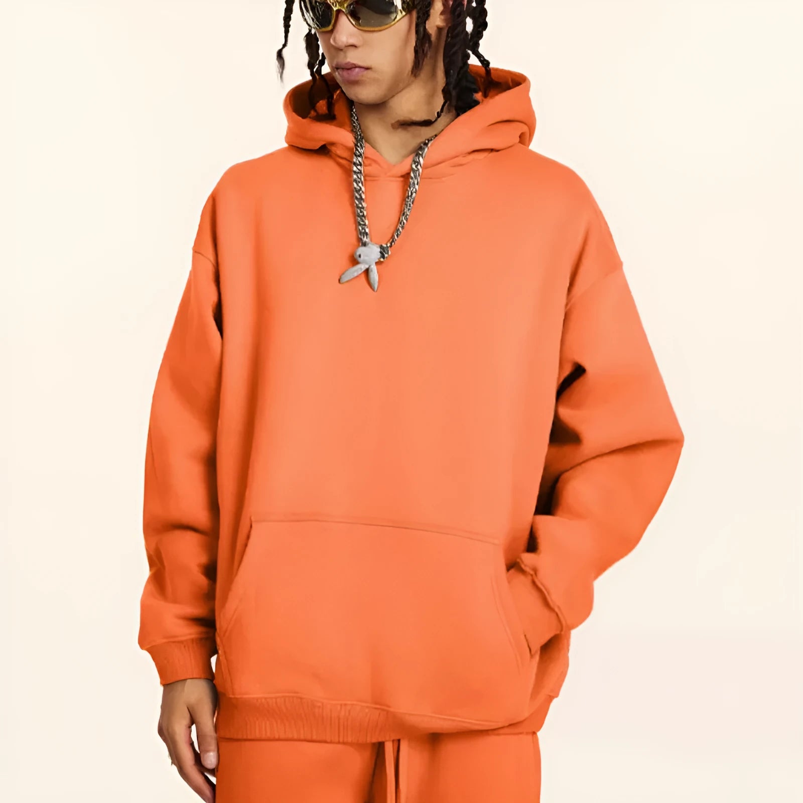 Man wearing a grey heavyweight cotton terry hooded sweater with a loose fit and drop-shoulder sleeves.