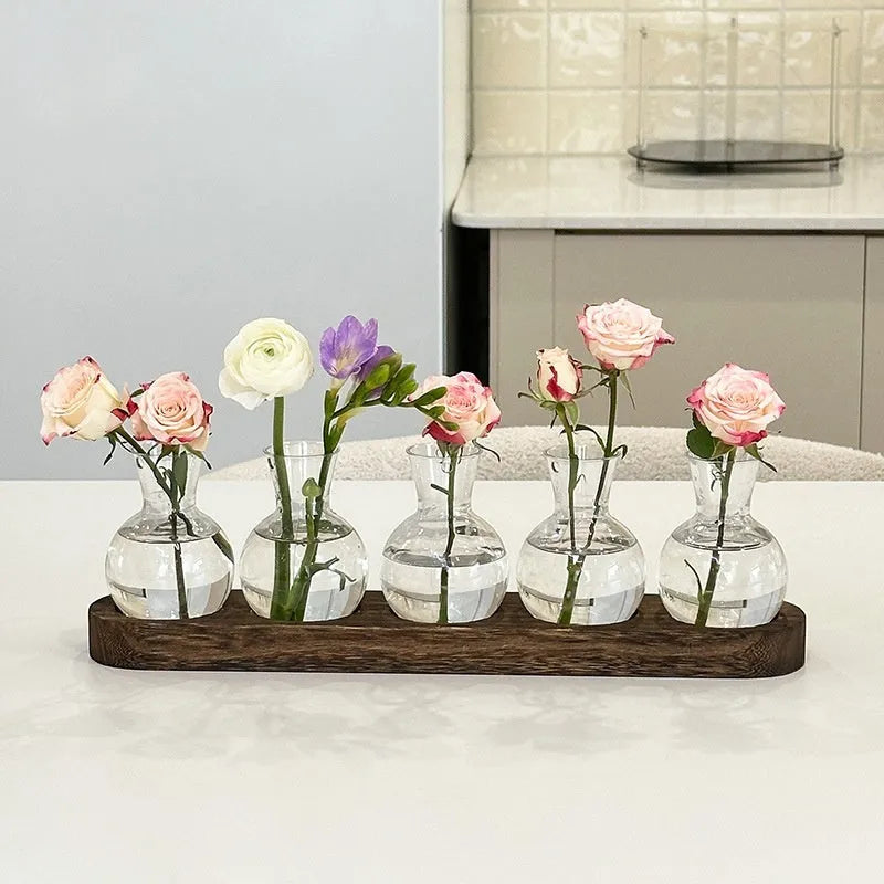 Transparent hydroponic vase in a wooden frame for modern plant display.