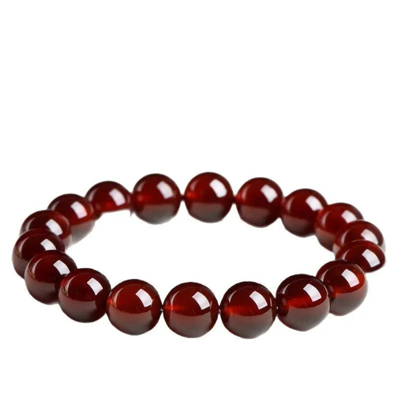 Close-up of an orange red garnet crystal bracelet with retro styling and Ruyi design details.