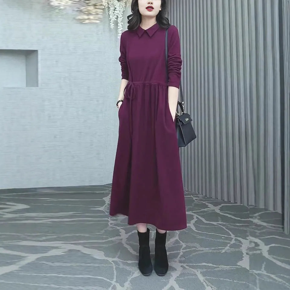 Purplish red long sleeve dress for women on a hanger, showing long skirt and extra long sleeves.