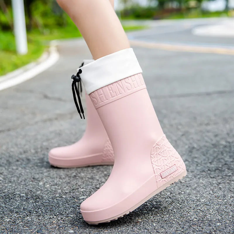 Women's solid colour PVC rain boots with non-slip sole in apricot, black, brown, and pink.