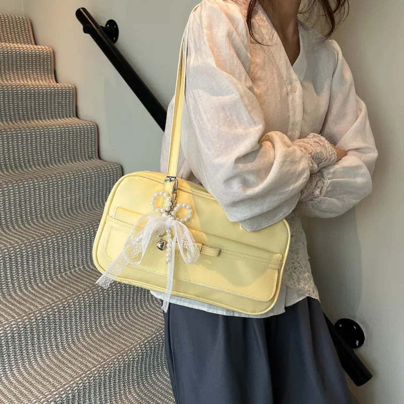 Single-shoulder flap bag in PU leather with bow stitching details and horizontal square shape