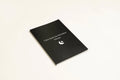 Black covered dream journal notebook open to show cream dot grid pages