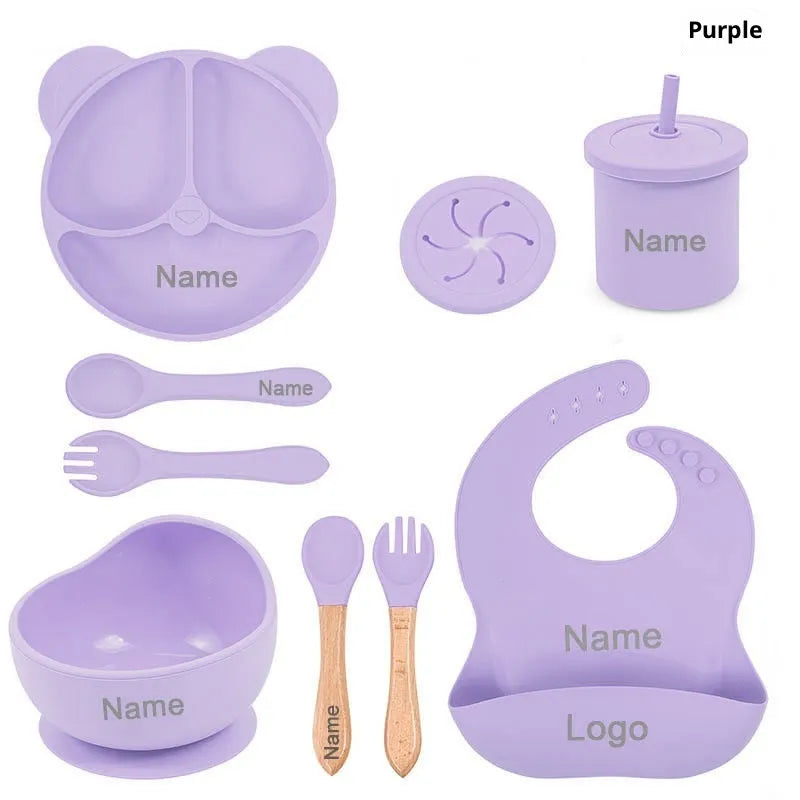 Children's silicone tableware set with cat ear cup in beige, blue and other colours on a table