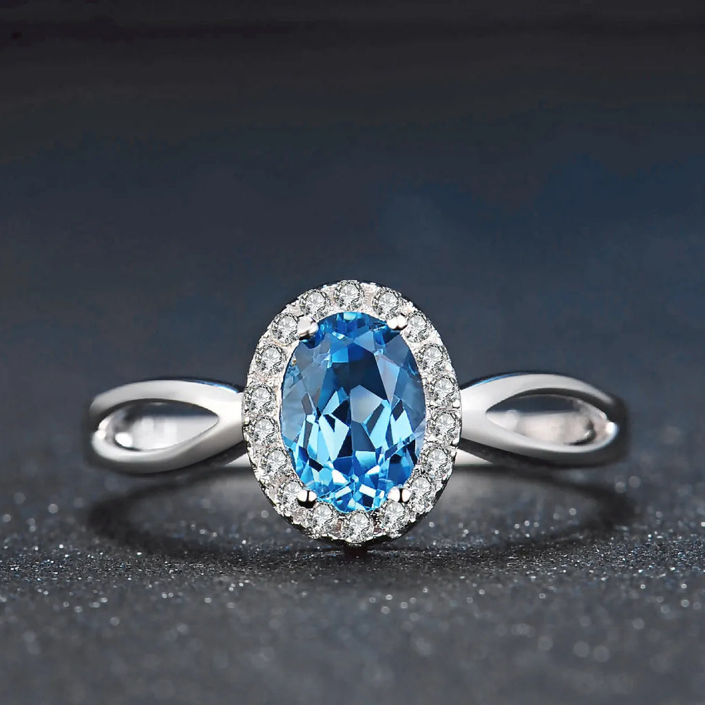 Geometric blue topaz and sterling silver four-piece jewellery set with earrings, ring, pendant, and necklace.