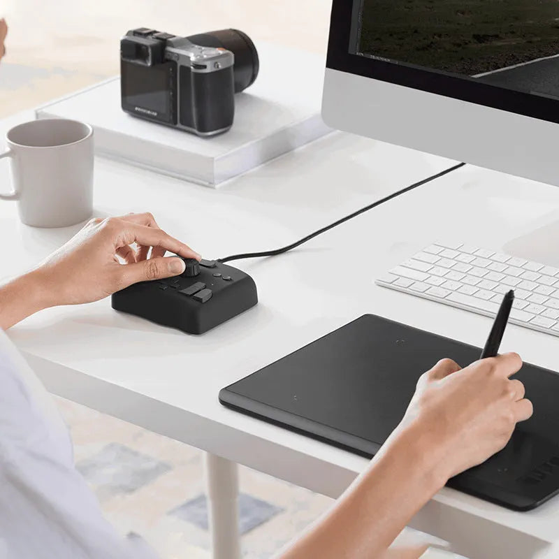 TourBox NEO programmable auxiliary keyboard for video editing and digital creation on a desktop.