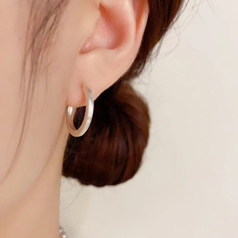 Women's simple geometric round copper ear clips with real gold plating in gold and silver colours showing eyelet design detail
