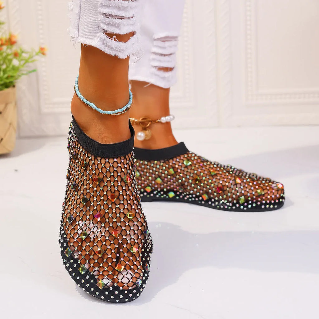 Women's flat sandals with mesh upper, colourful rhinestone decoration, and a rubber sole.