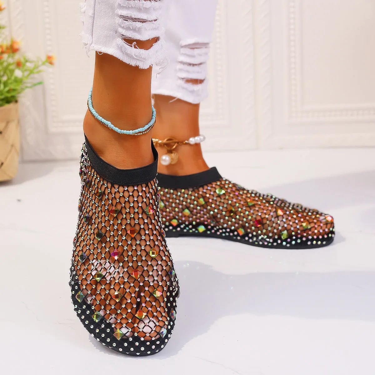 Women's flat sandals with mesh upper, colourful rhinestone decoration, and a rubber sole.
