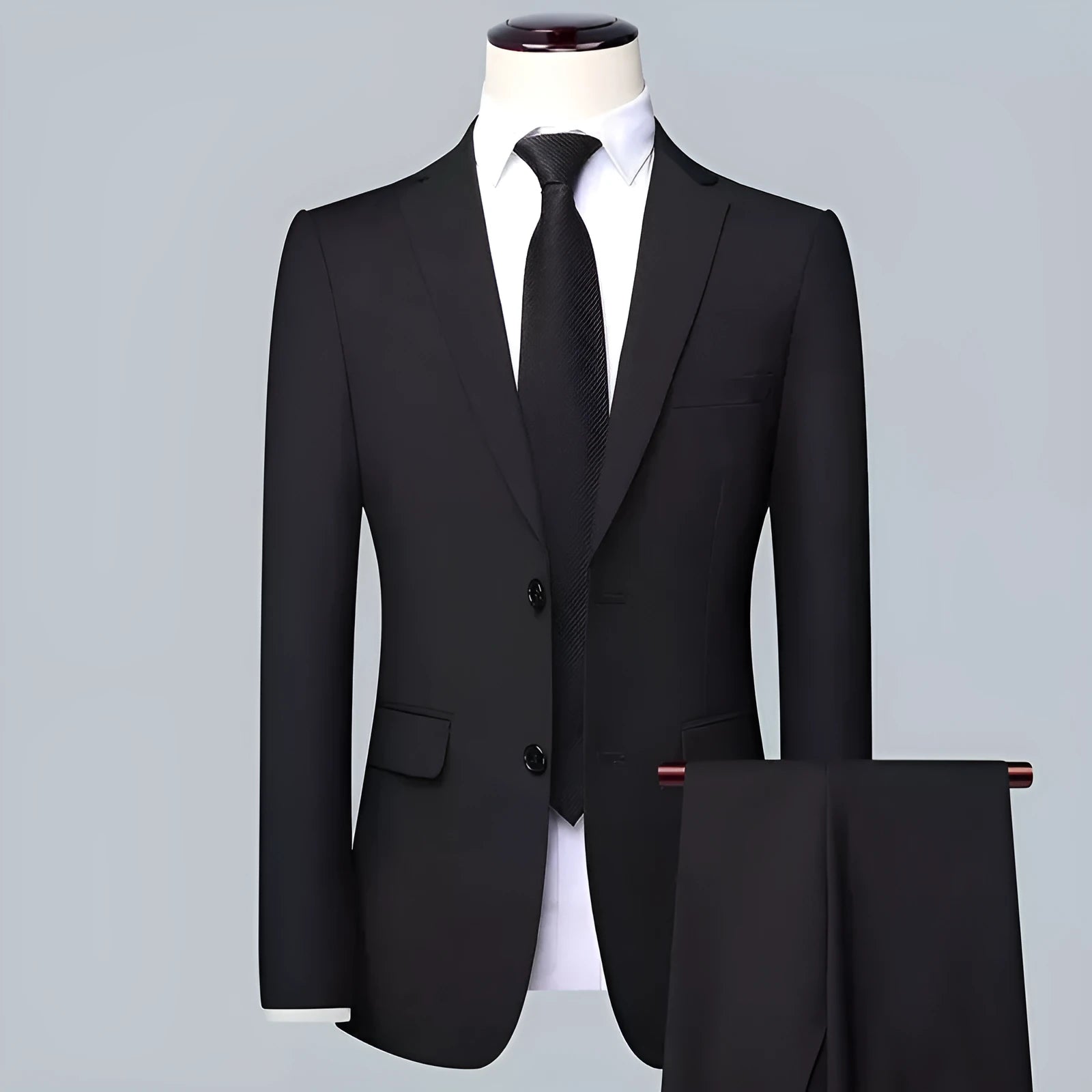 Men's slim fit three-piece suit set in black, including jacket, trousers, and tie on a hanger.