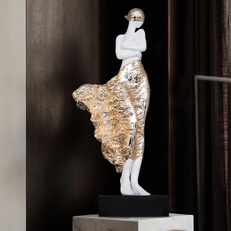 Tall modern minimalist sculpture ornament in rose gold finish on a wooden surface.
