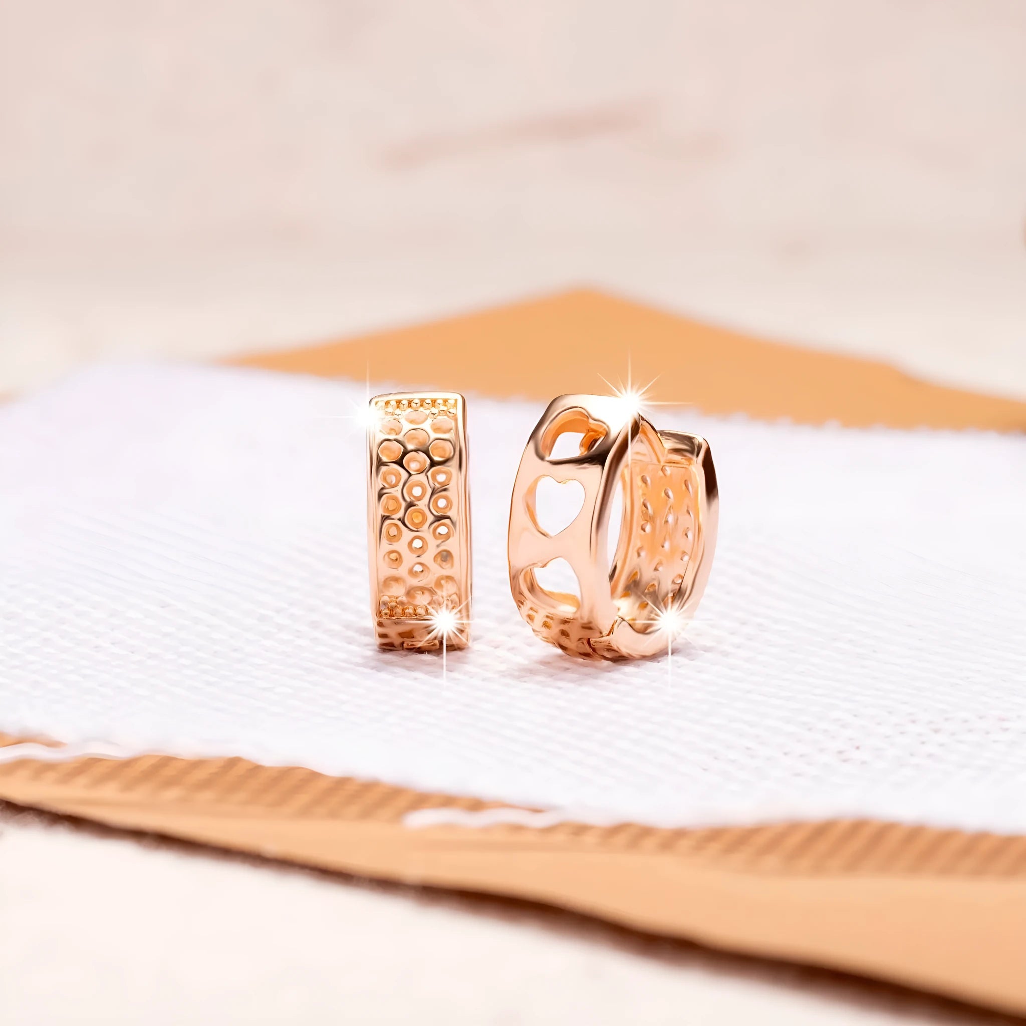 A pair of rose gold hollow heart-shaped earrings for women on a white background.