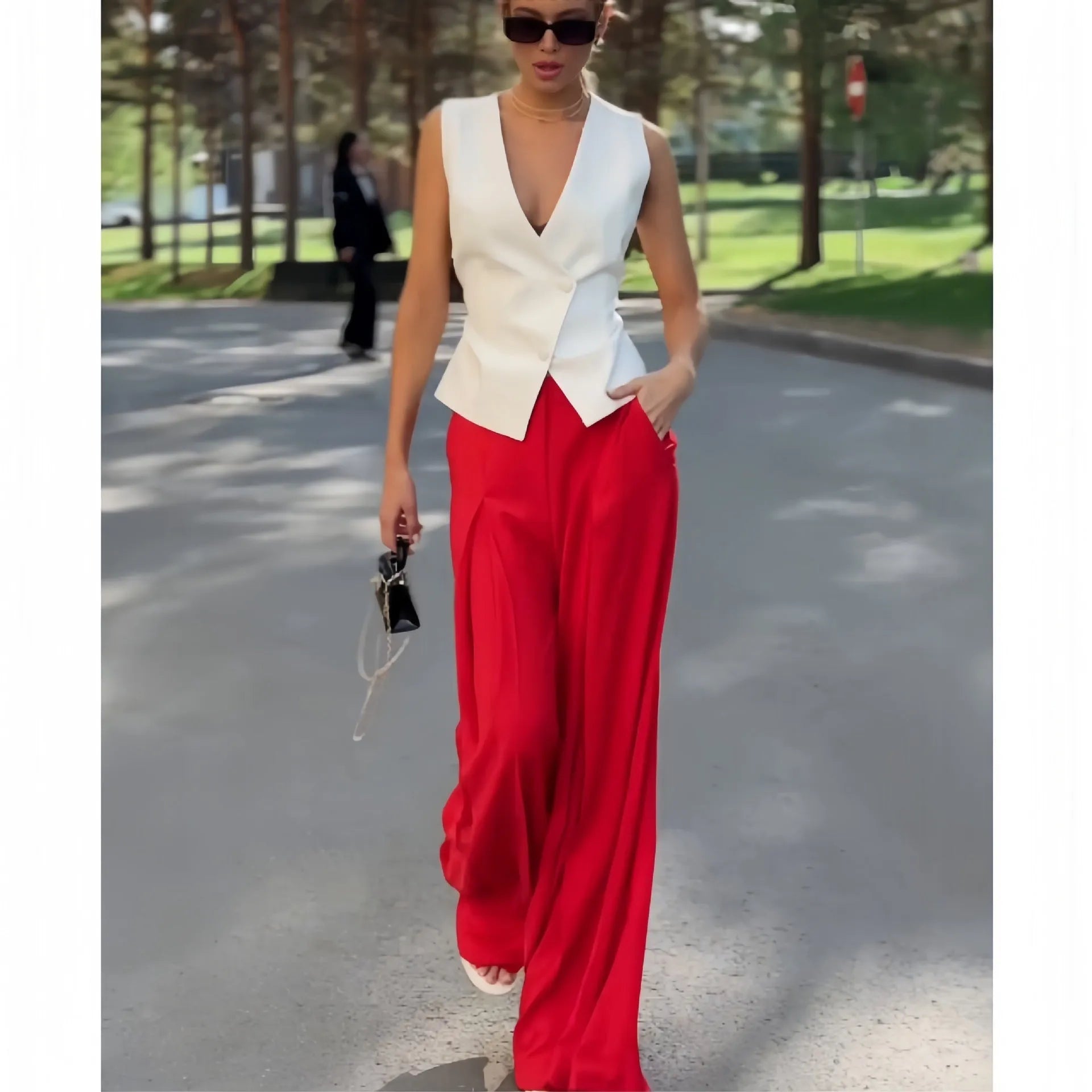 Women's beige two-piece set with deep V-neck sleeveless top and high-waisted wide leg trousers.