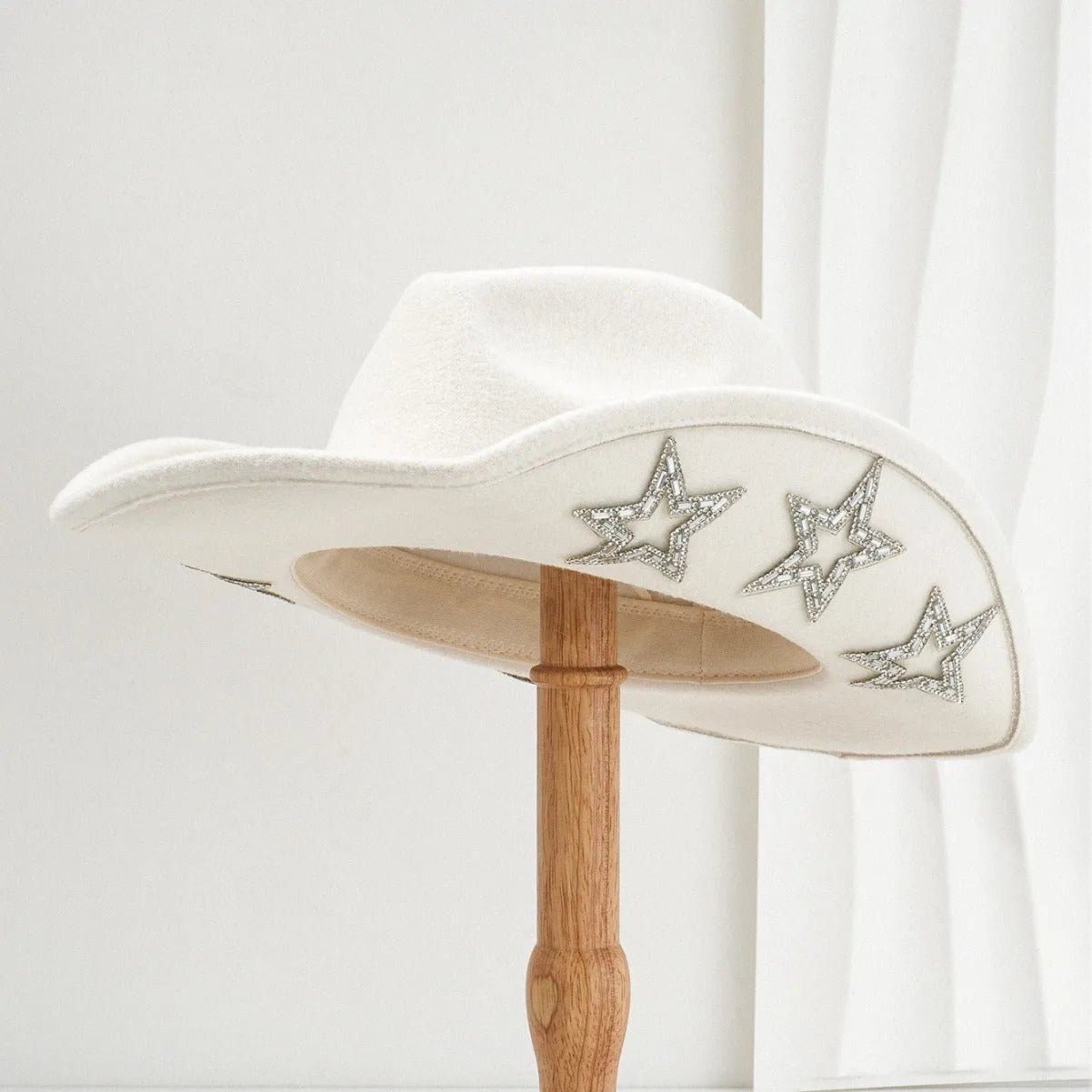 Beige polyester western denim top hat with a conical crown and a silver hexagonal star decoration on the front.