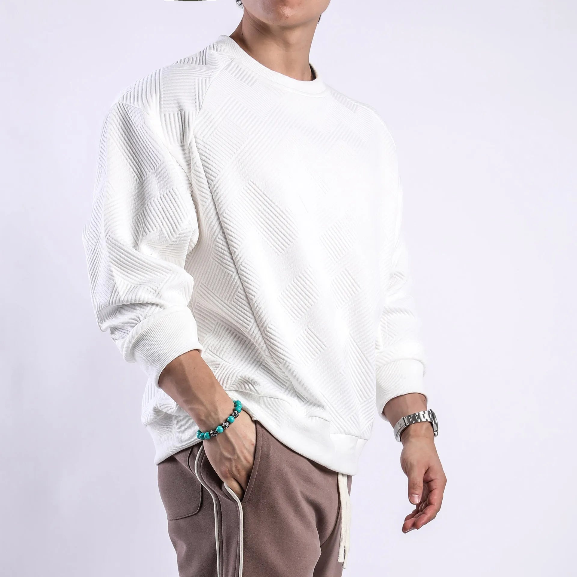 Men's loose fit long-sleeved twill jacquard sweater in a solid colour on a hanger