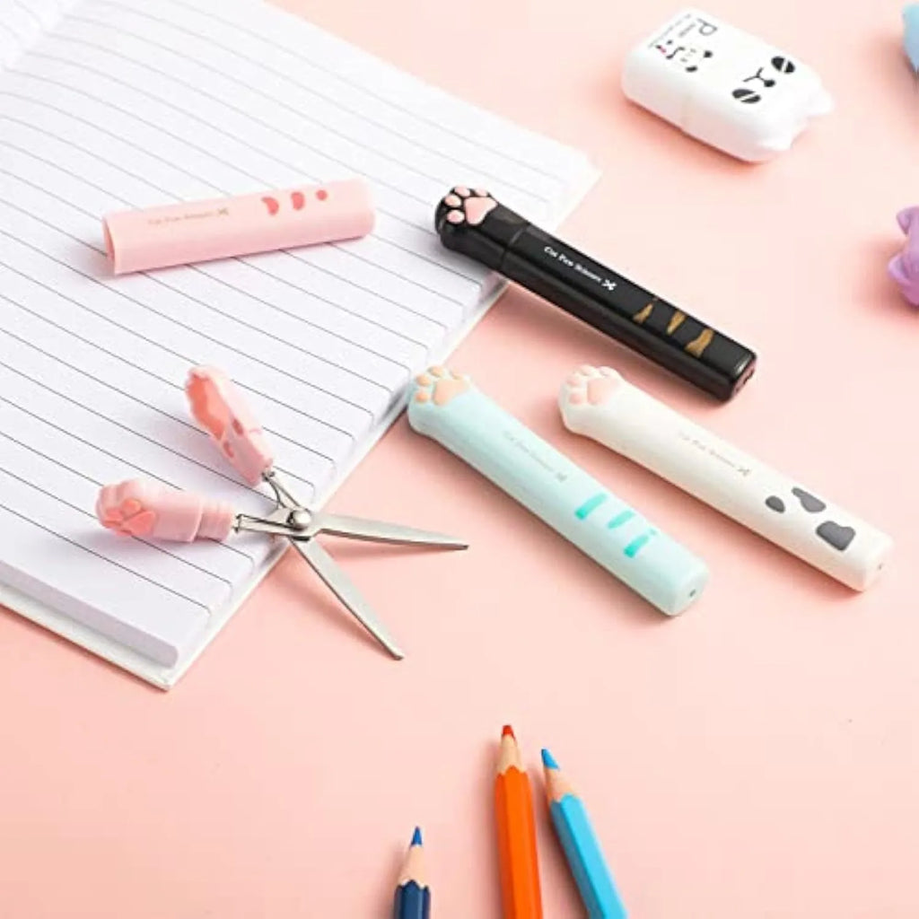 Small stainless steel folding scissors with cat paw handles shown in pink, blue, black, and white.
