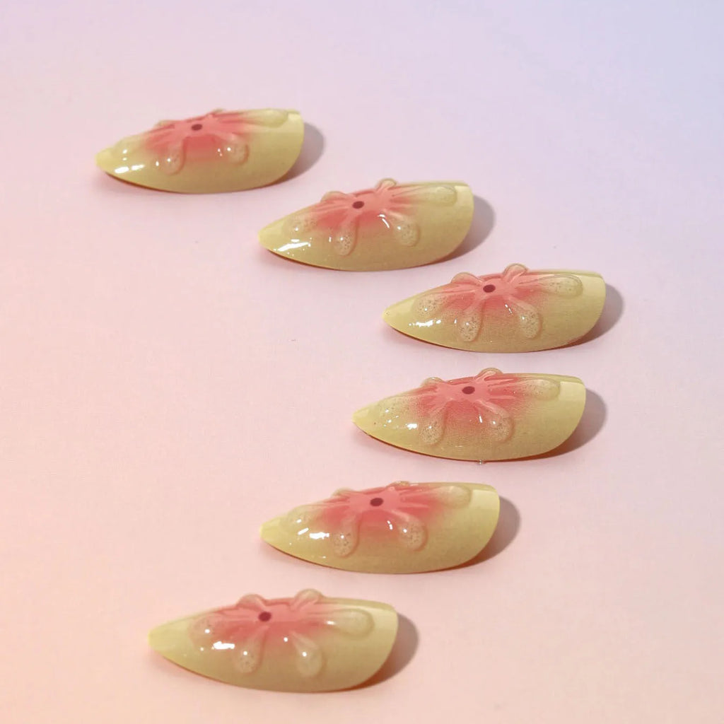 Cartoon 3D flower design on plastic fake nail armour pieces from a detachable nail kit.