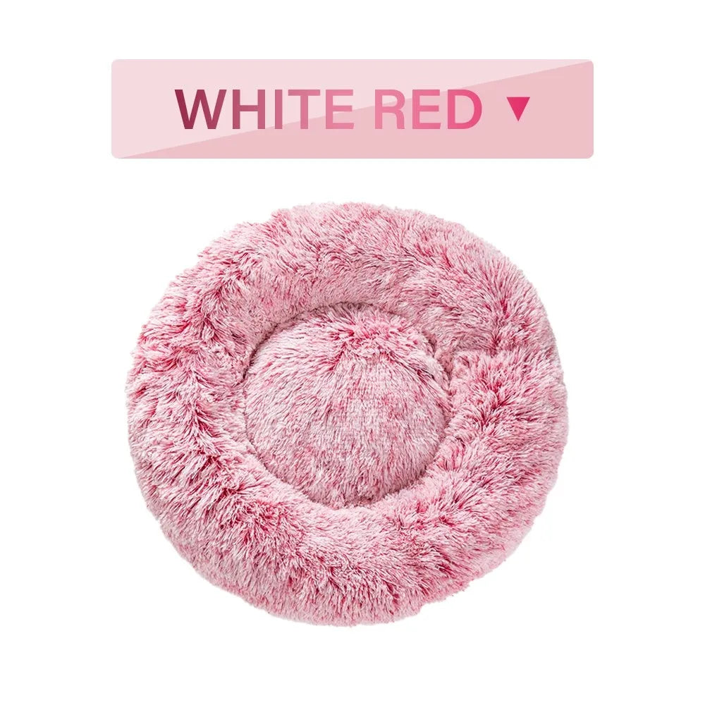 Fluffy donut-shaped dog bed in long plush material, shown in a light grey colour.