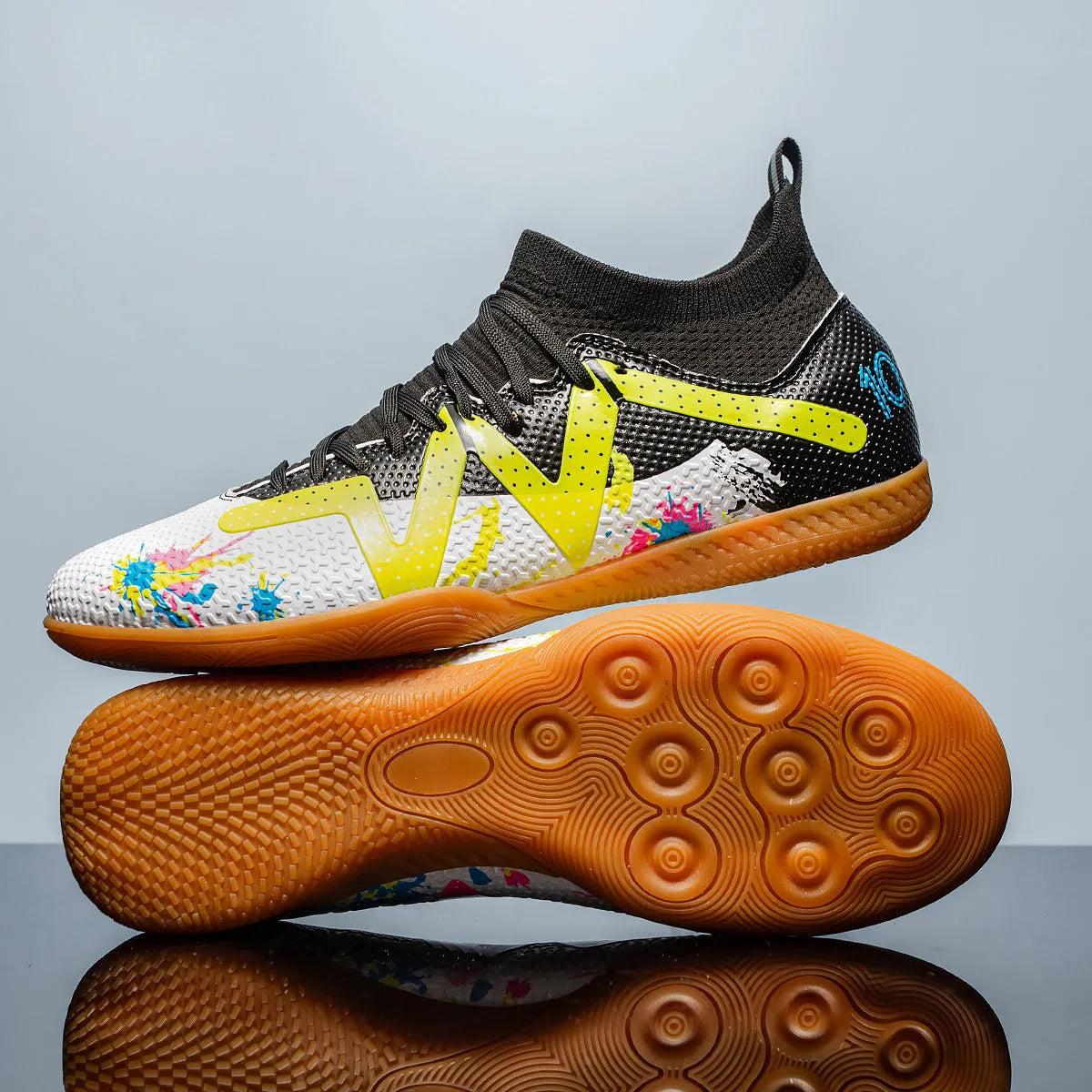 Adult low-top soccer shoes in black and yellow, showing studded rubber sole and printed PVC upper.
